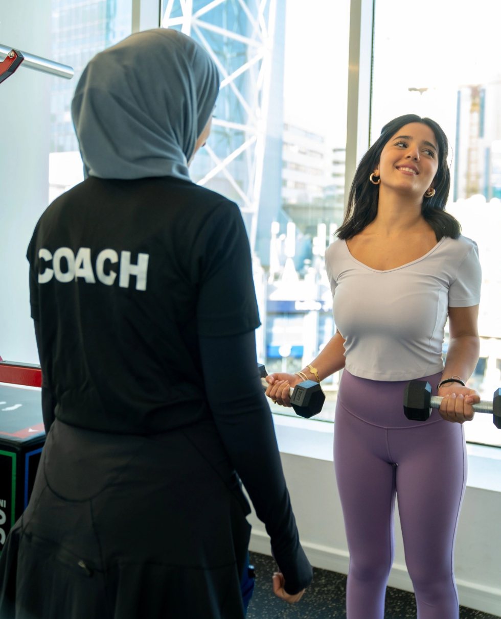 A coach guiding a personal training session at ADOO Studio